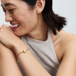 mulher-mao-no-ombro-sorrindo-usando-bracelete