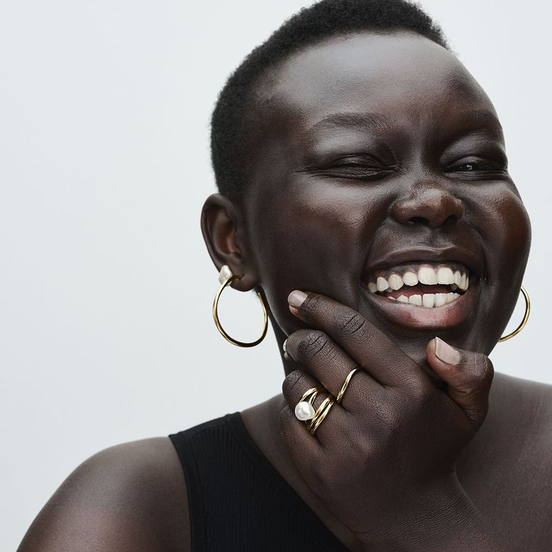 mulher-sorrindo-usando-brinco-e-aneis