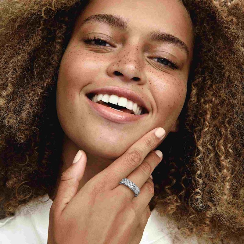 mulher-sorrindo-mao-no-rosto-usando-anel